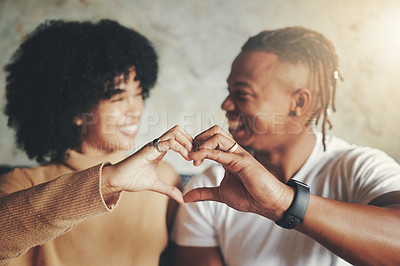 Buy stock photo Shot of a young couple making a heart shape with their hands