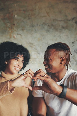 Buy stock photo Shot of a young couple making a heart shape with their hands
