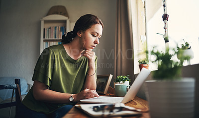 Buy stock photo Shot of a young woman using a laptop while working from home