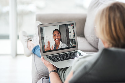 Buy stock photo Shot of a senior woman using a laptop to make a video call with her doctor on the sofa a home