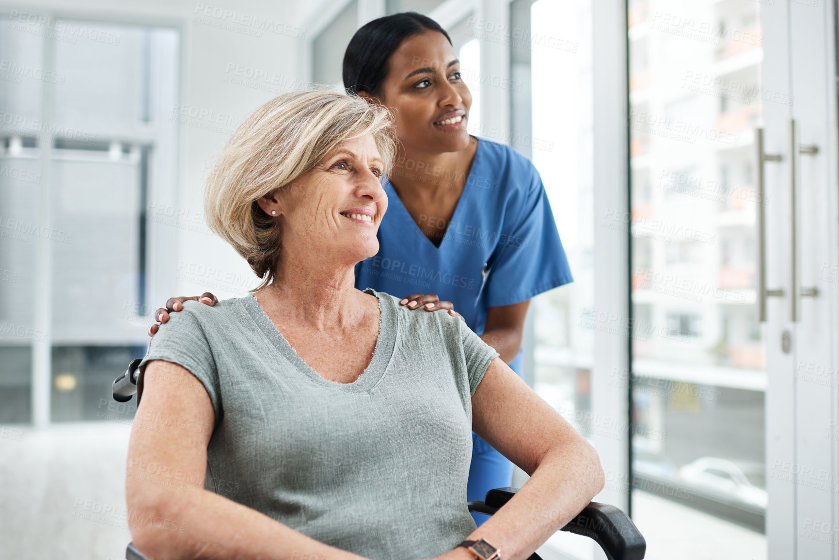 Buy stock photo Shot of a young nurse caring for a senior woman in a wheelchair