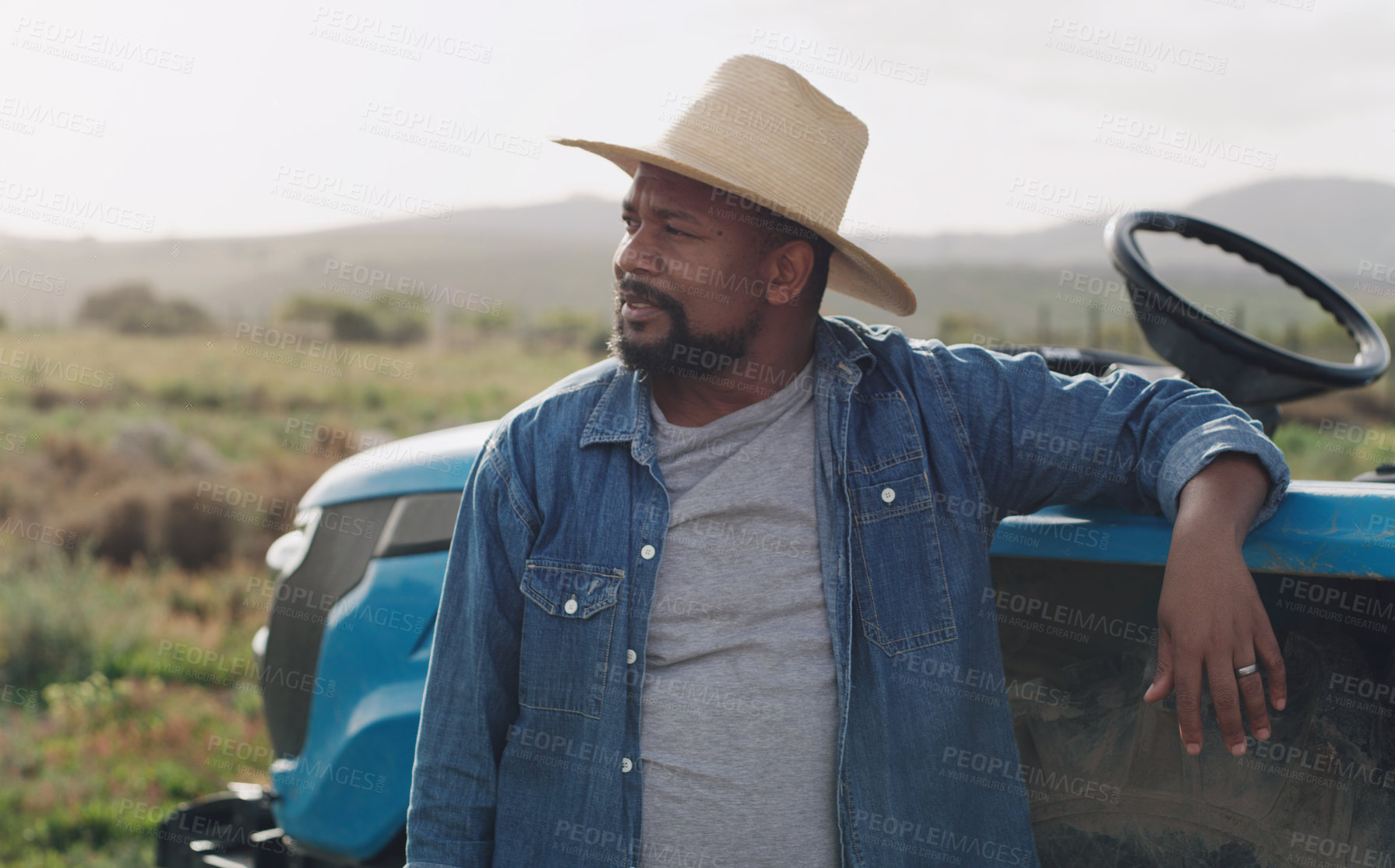 Buy stock photo Farming, thinking and a black man with a tractor on a farm for agriculture growth and sustainability. Idea, planning and an African farmer in the countryside with ideas for sustainable business