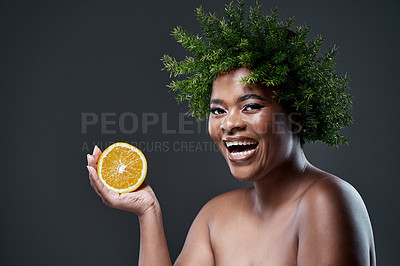 Buy stock photo Shot of a beautiful woman holding an orange and wearing a leaf wreath on her head