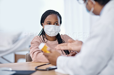 Buy stock photo Shot of a young woman receiving medication from a doctor during a consultation