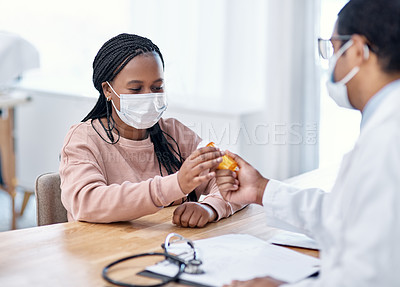 Buy stock photo Shot of a young woman receiving medication from a doctor during a consultation