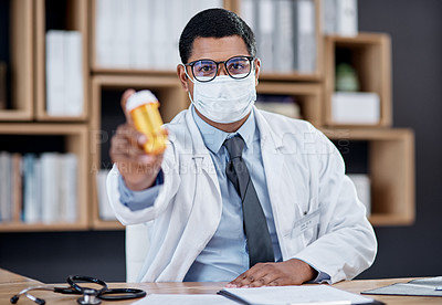 Buy stock photo Doctor selling medicine for covid at medical consultation, sitting behind office desk in hospital. Healthcare professional consulting offer bottle of pills for treatment, wearing mask for protection.