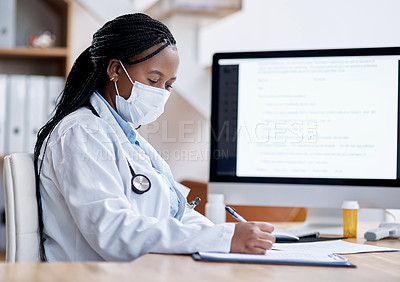 Buy stock photo Shot of a young doctor writing notes while working in her office
