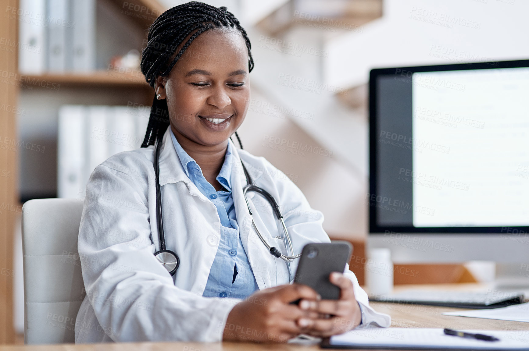 Buy stock photo Shot of a young doctor using a cellphone while working in her office