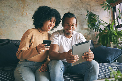 Buy stock photo Shot of a young couple using their digital devices at home
