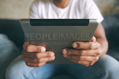 Buy stock photo Closeup shot of an unrecognisable man using a digital tablet at home