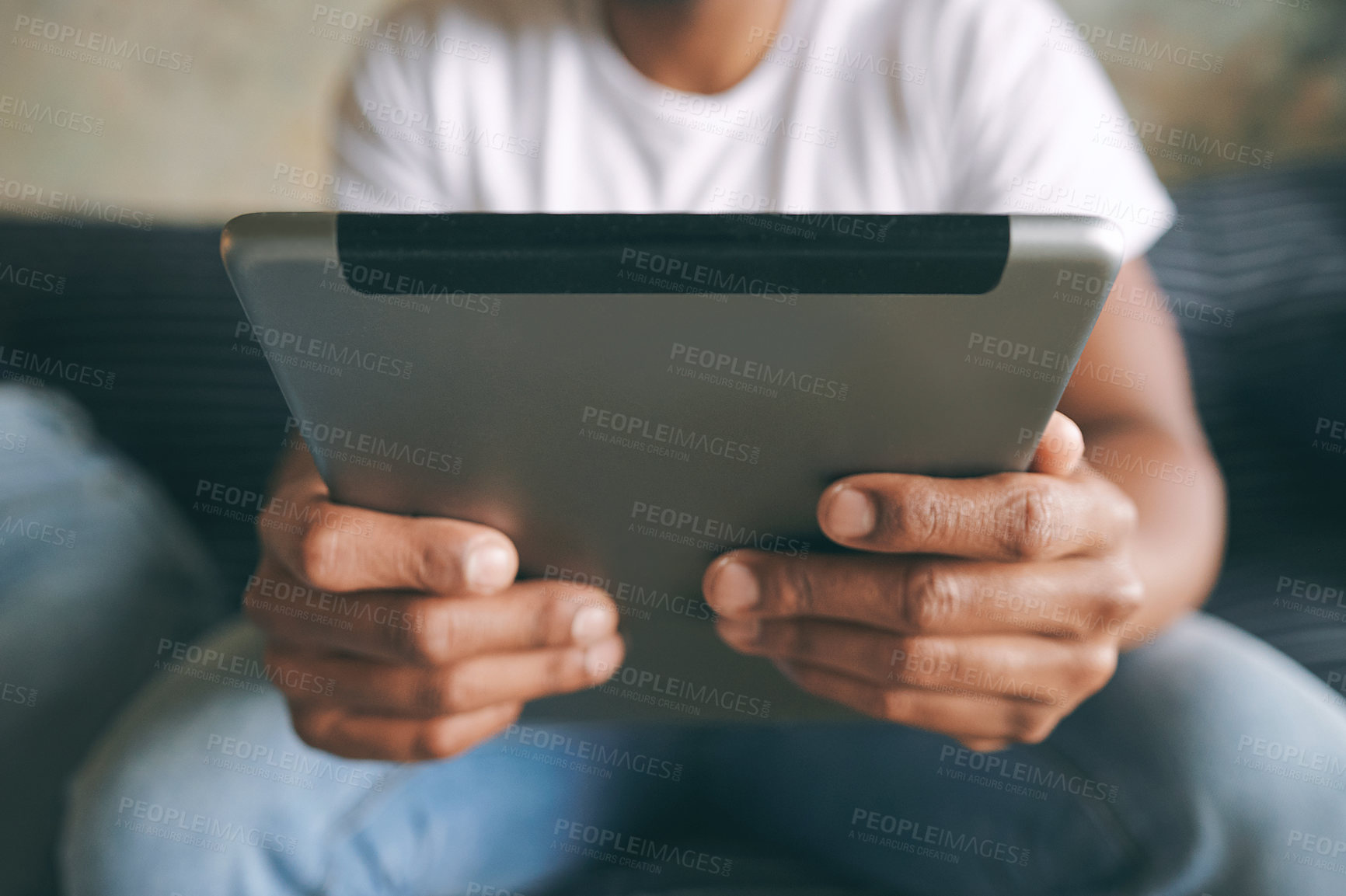 Buy stock photo Closeup shot of an unrecognisable man using a digital tablet at home