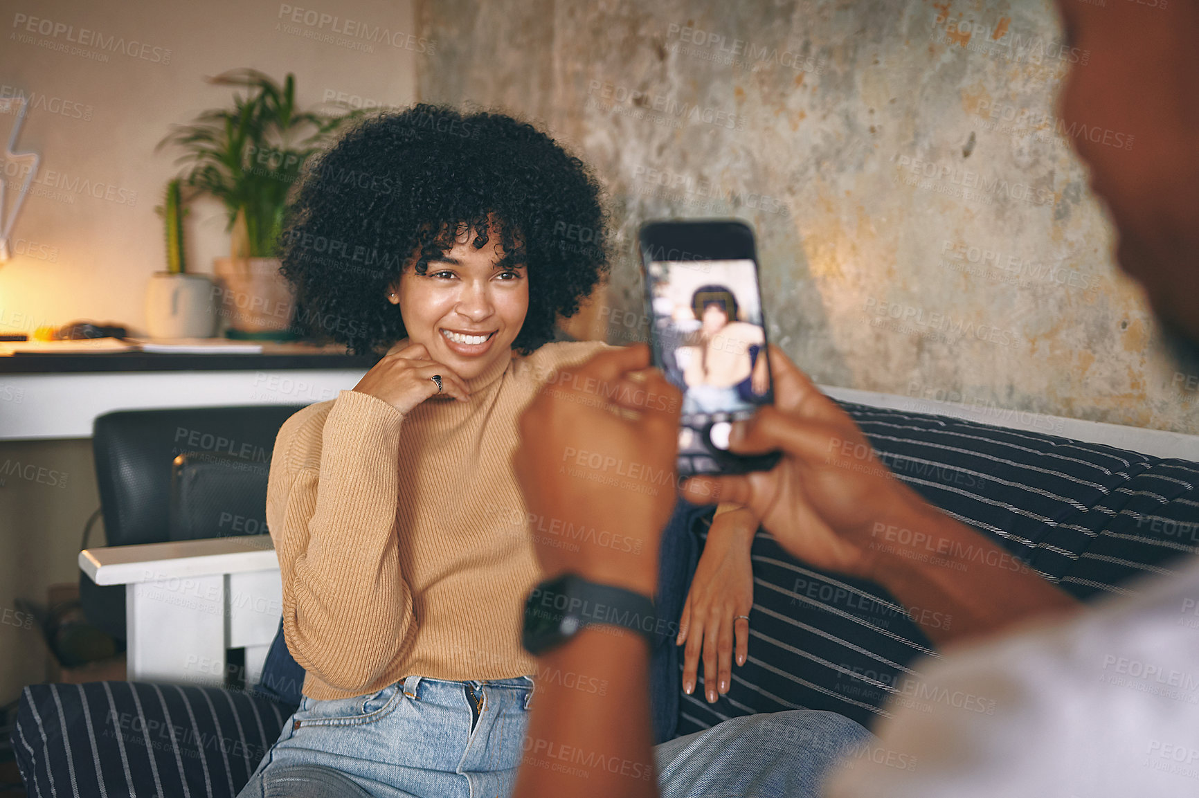 Buy stock photo Shot of a young woman posing while her boyfriend takes photos at home