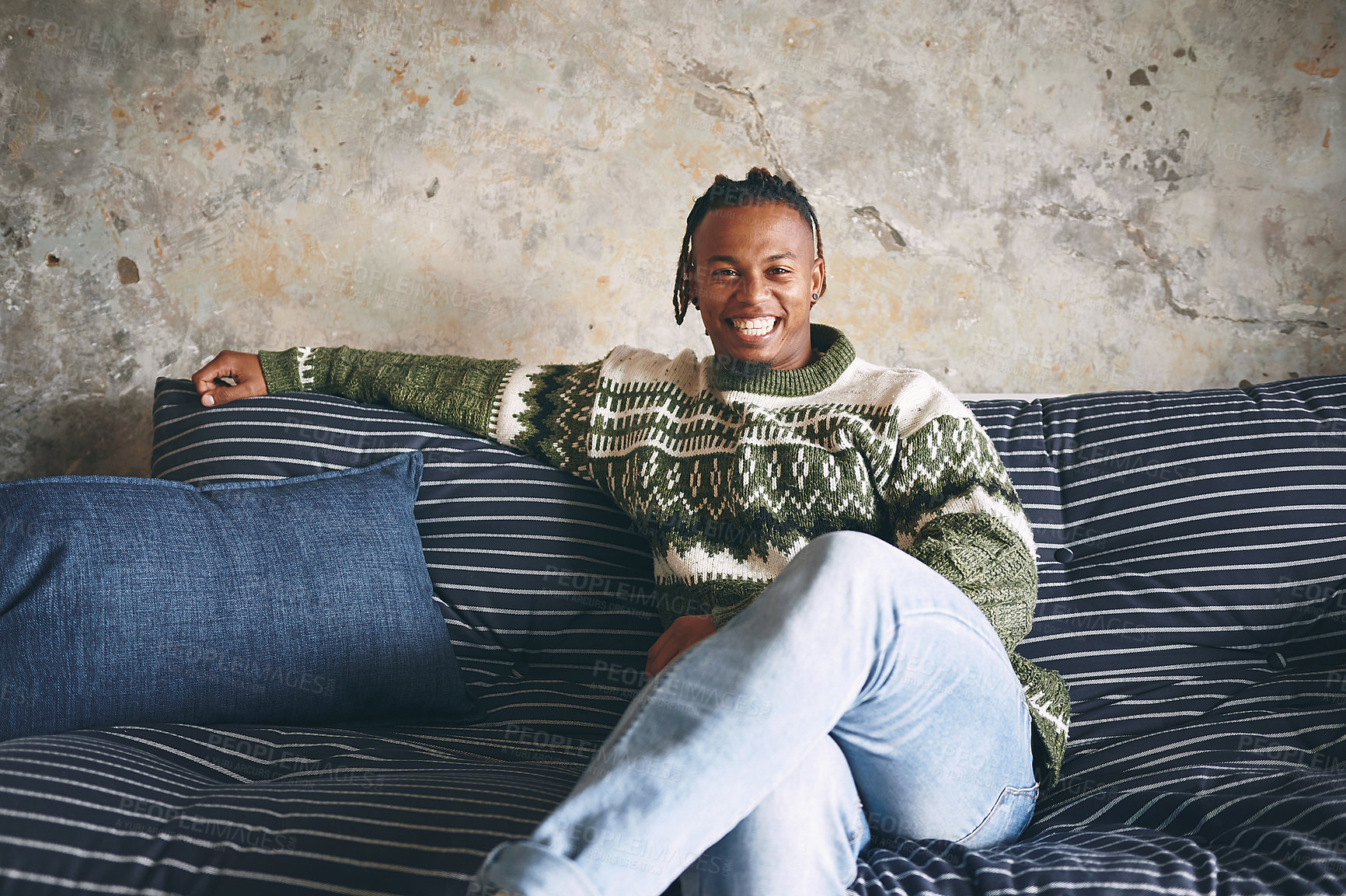 Buy stock photo Portrait of if a young man relaxing on a sofa at home