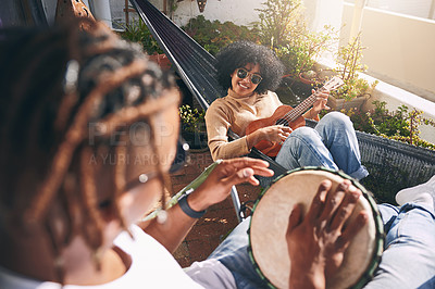 Buy stock photo Shot of a young woman playing ukulele while her boyfriend plays drums