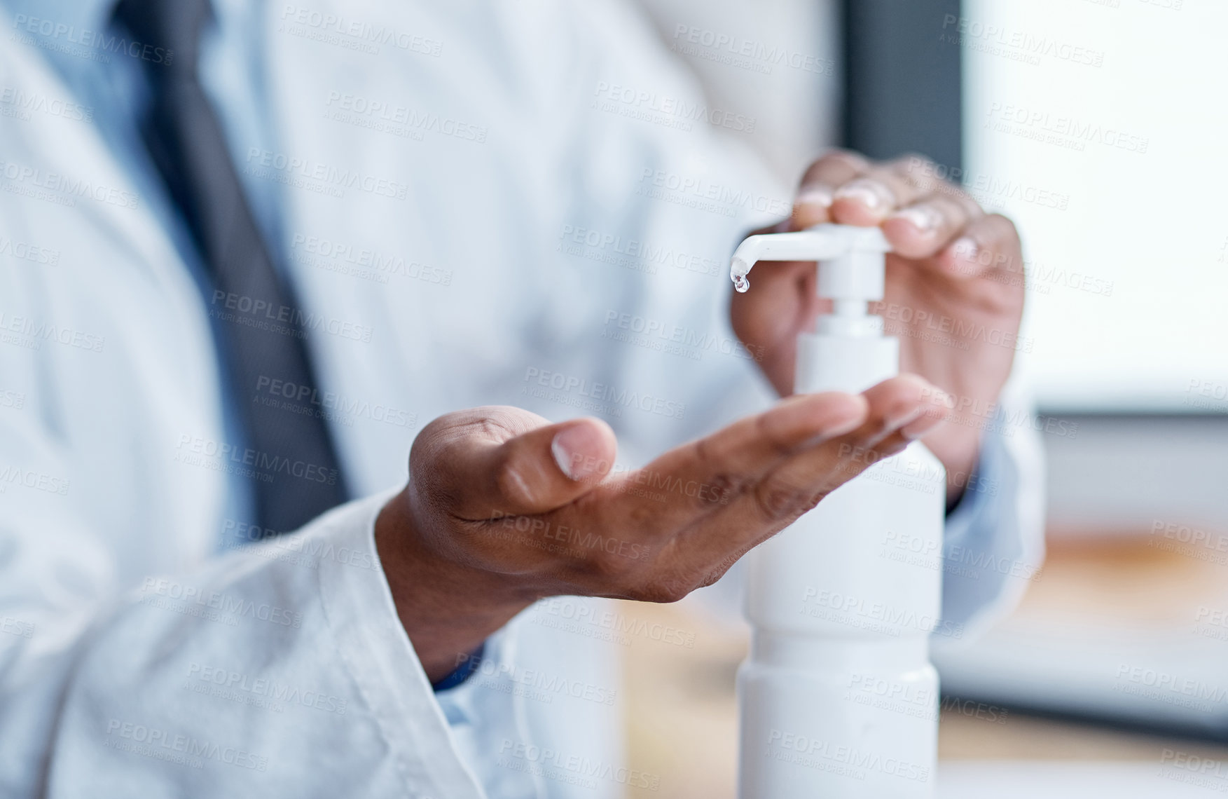 Buy stock photo Closeup shot of an unrecognisable doctor using hand sanitiser in a hospital