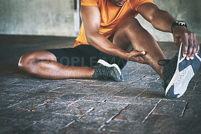Buy stock photo Cropped shot of a man stretching during a workout against an urban background