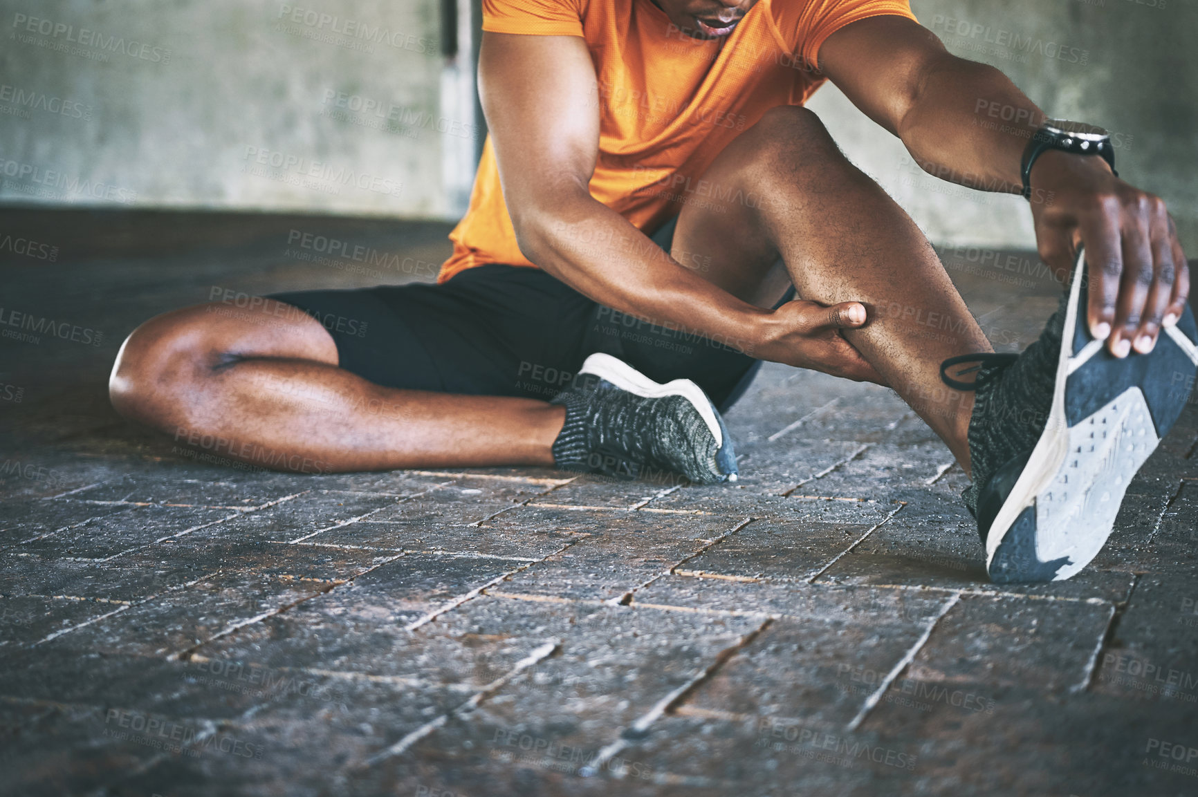 Buy stock photo Cropped shot of a man stretching during a workout against an urban background