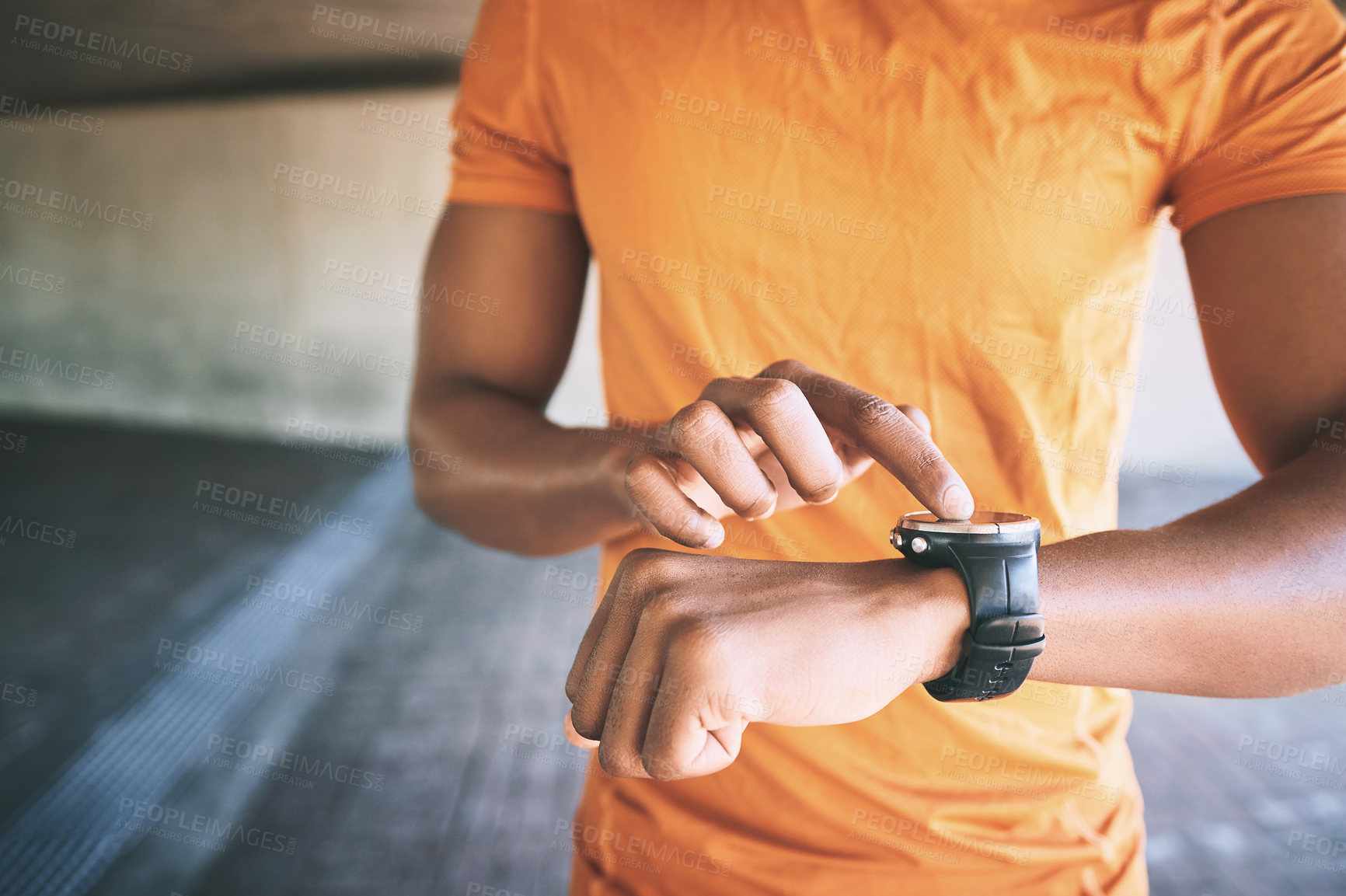 Buy stock photo Cropped shot of a man looking at his watch during a workout against an urban background