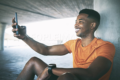 Buy stock photo Shot of a young man using a smartphone to take a selfie during a workout against an urban background