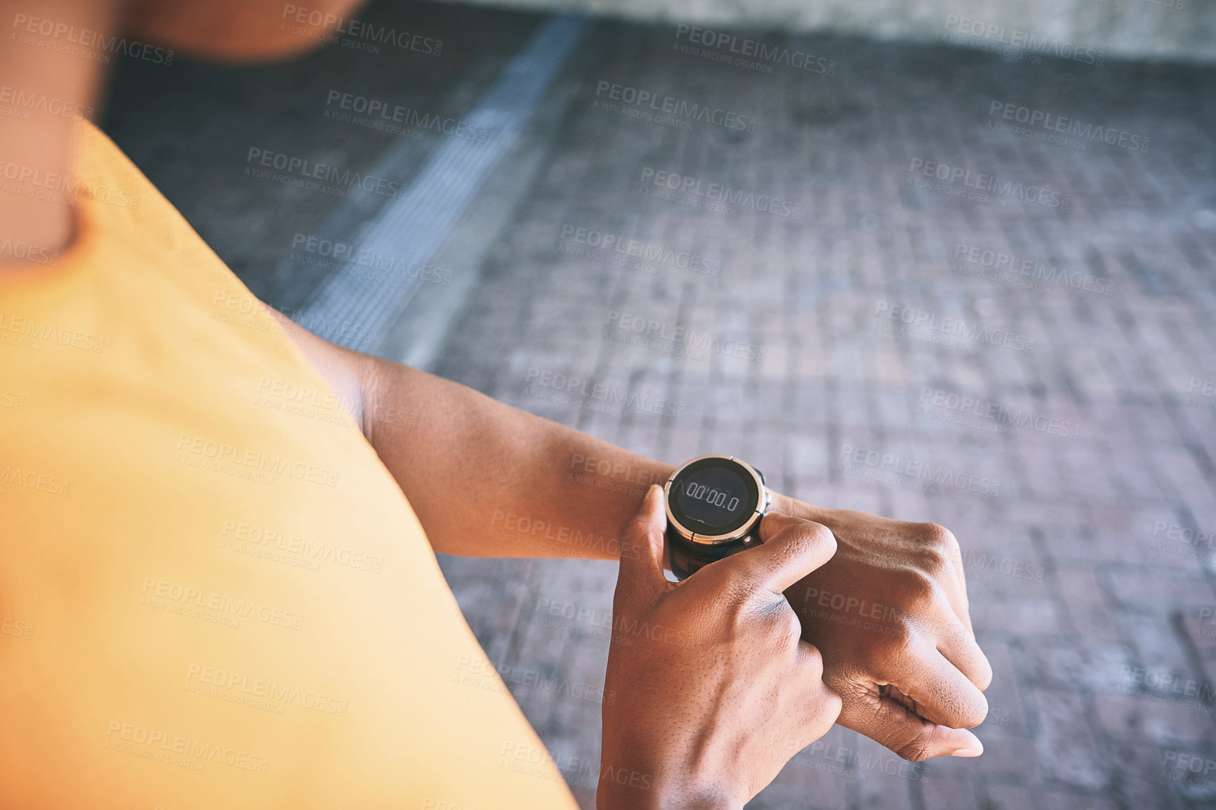 Buy stock photo Cropped shot of a man looking at his watch during a workout against an urban background