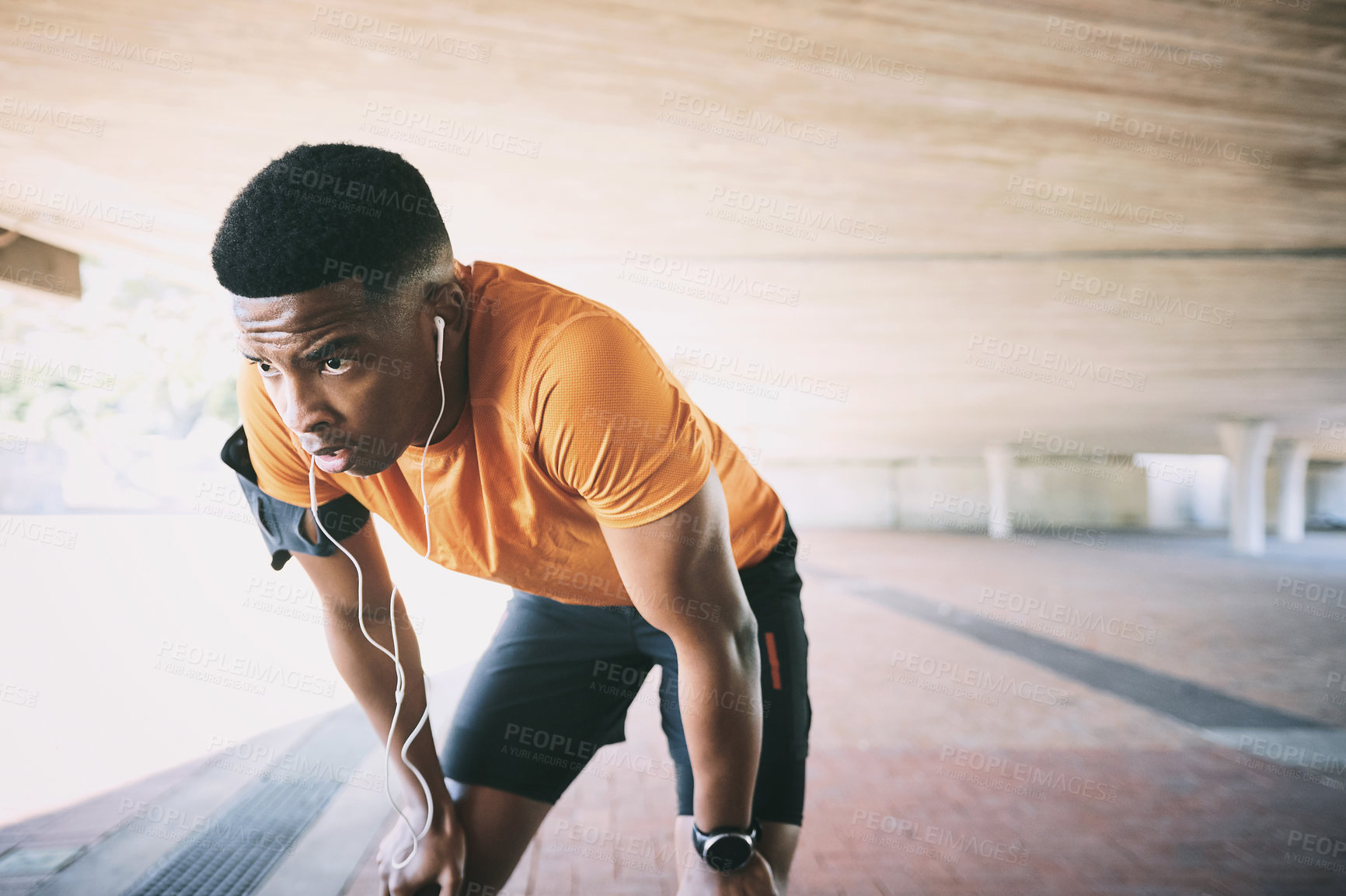 Buy stock photo Shot of a young man taking a break after working out against an urban background