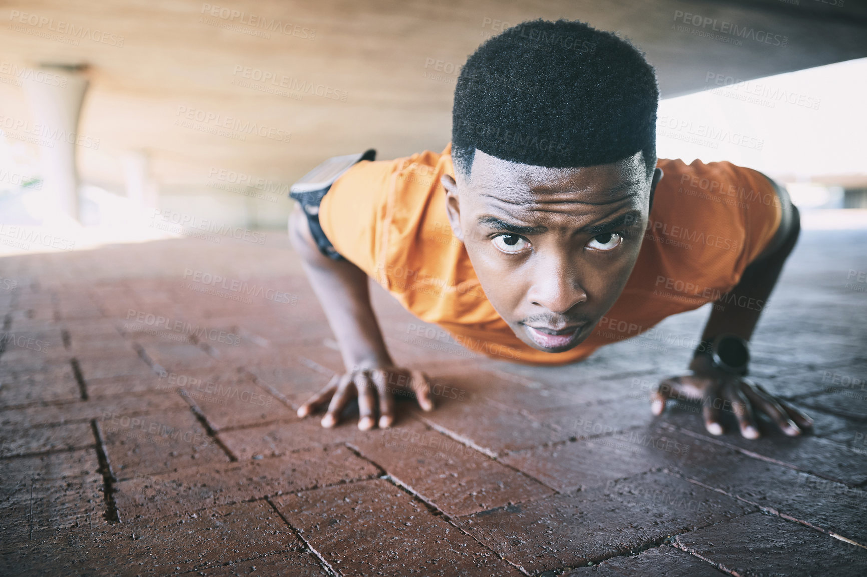 Buy stock photo Shot of a young man doing pushups against an urban background