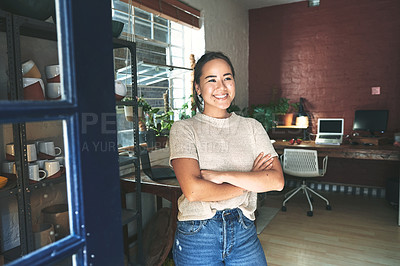 Buy stock photo Cropped shot of an attractive young business owner standing alone in her pottery studio with her arms folded