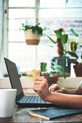 Buy stock photo Cropped shot of an unrecognizable business owner sitting alone in her studio and using a laptop for online shopping