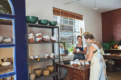 Buy stock photo Shot of two young women making mugs in a pottery studio