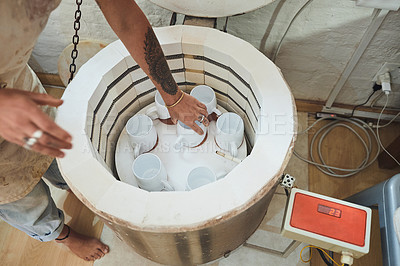 Buy stock photo Shot of an unrecognisable woman using an electric kiln in a pottery studio