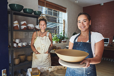 Buy stock photo Shot of two young women making a bowl in a pottery studio