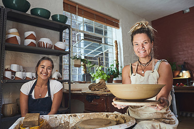 Buy stock photo Shot of two young women making a bowl in a pottery studio