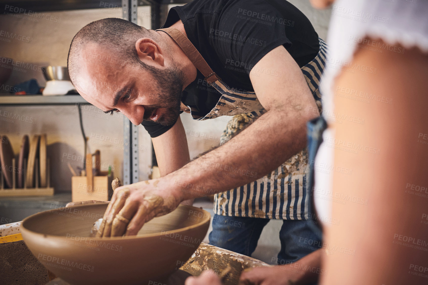 Buy stock photo Shot of a young man and woman working with clay in a pottery studio