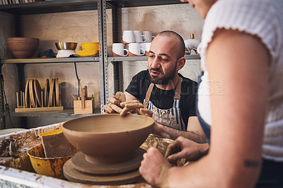 Buy stock photo Shot of a young man and woman working with clay in a pottery studio