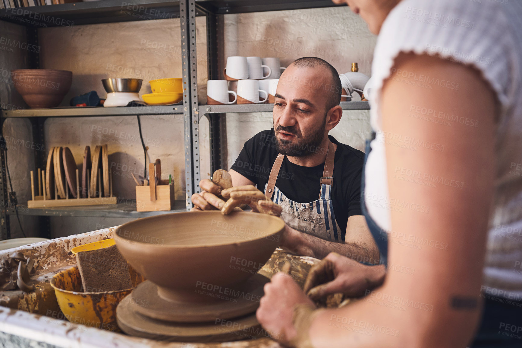 Buy stock photo Shot of a young man and woman working with clay in a pottery studio