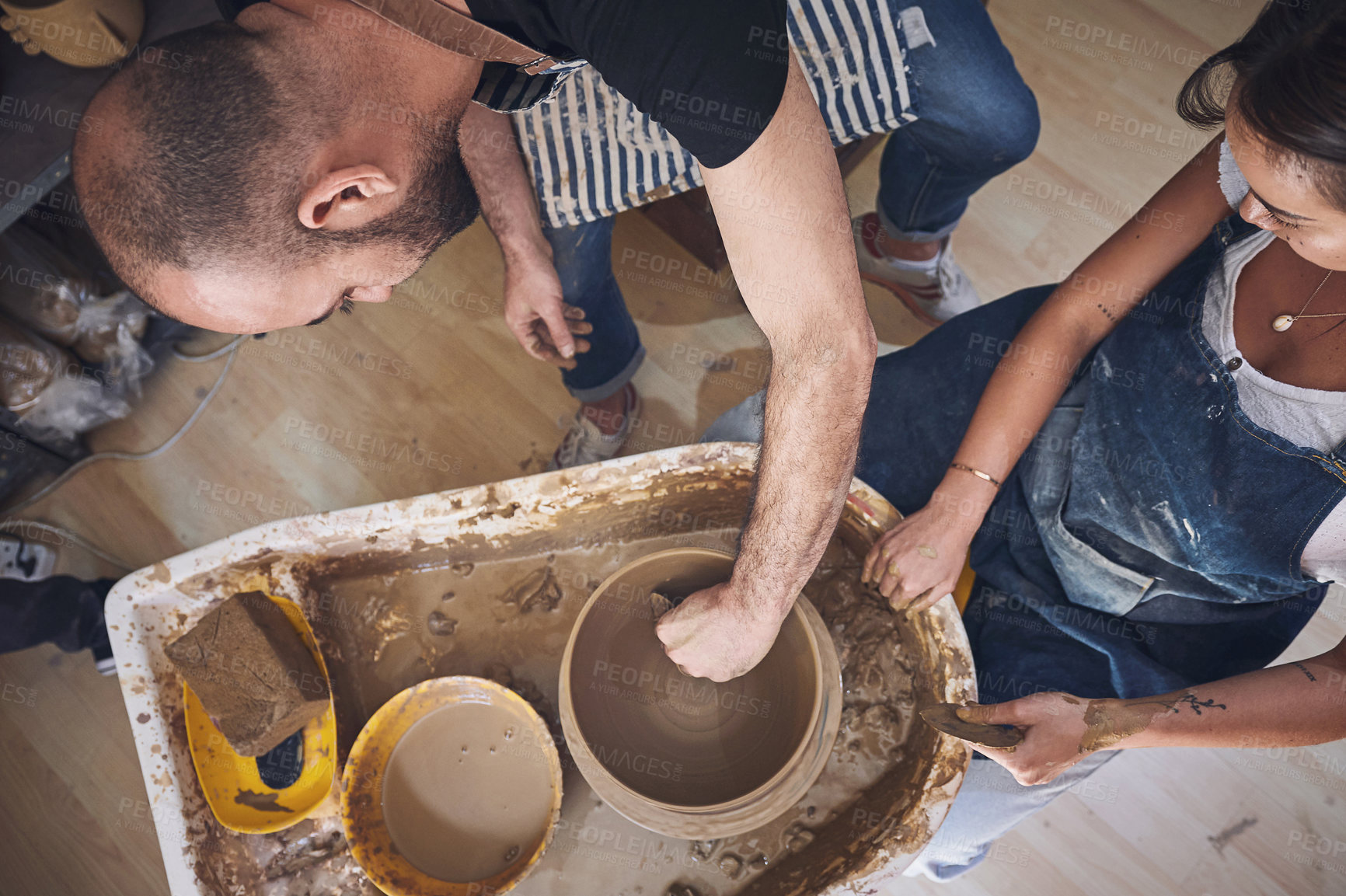 Buy stock photo Shot of a young man and woman working with clay in a pottery studio