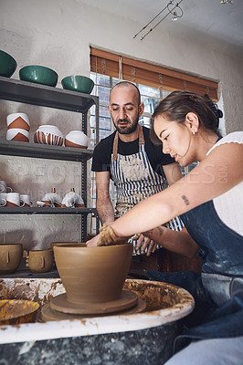 Buy stock photo Shot of a young man and woman working with clay in a pottery studio