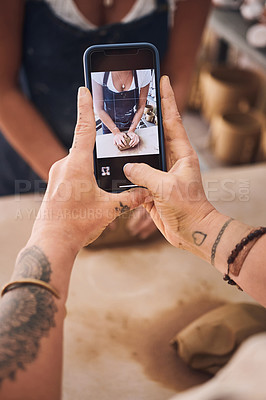 Buy stock photo Shot of a woman using a smartphone to take pictures of her friend in a pottery studio