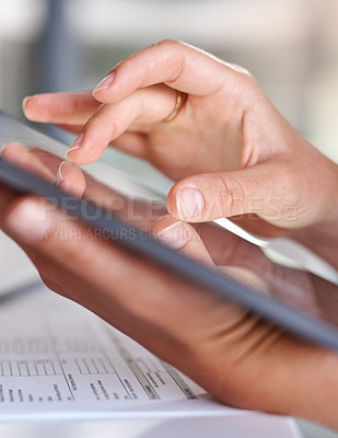 Buy stock photo Closeup shot of an unrecognisable businesswoman using a digital tablet while going through paperwork in an office