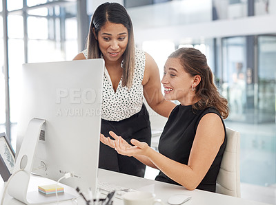 Buy stock photo Shot of two businesswomen working together on a computer in an office