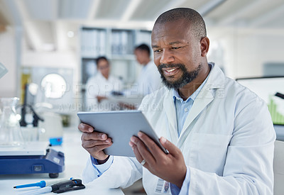 Buy stock photo Shot of a mature scientist using a digital tablet in a lab