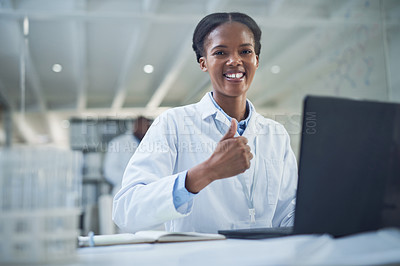 Buy stock photo Portrait of a young scientist showing thumbs up while working on a laptop in a lab