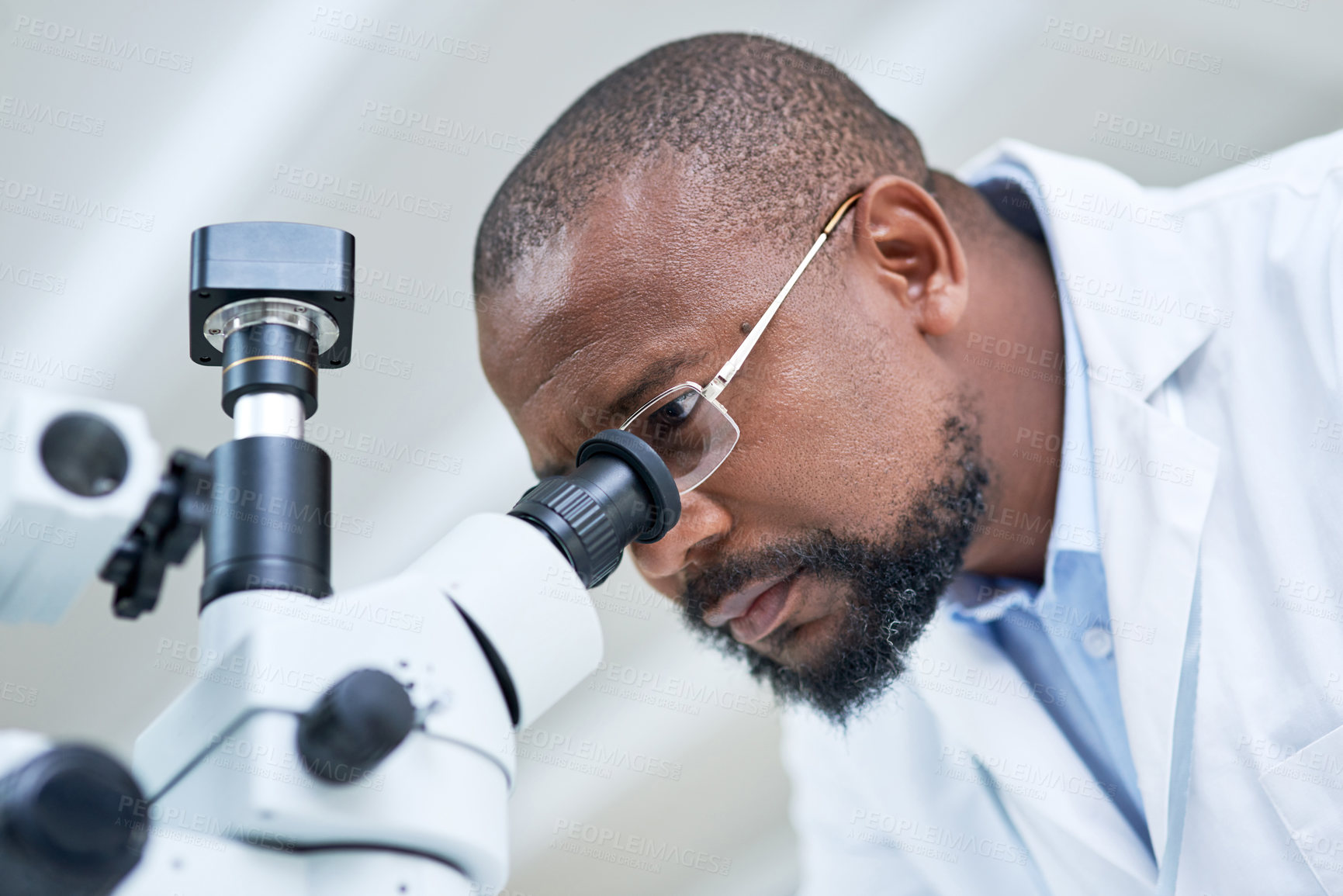 Buy stock photo Shot of a mature scientist using a microscope in a lab