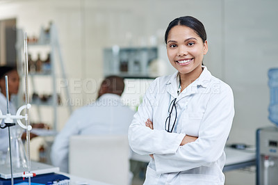 Buy stock photo Portrait of a young scientist standing with her arms crossed in a lab