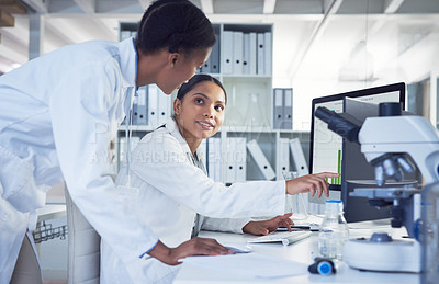 Buy stock photo Shot of two scientists working together in a computer in a lab
