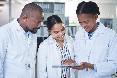 Buy stock photo Shot of a group of scientists using a digital tablet in a laboratory