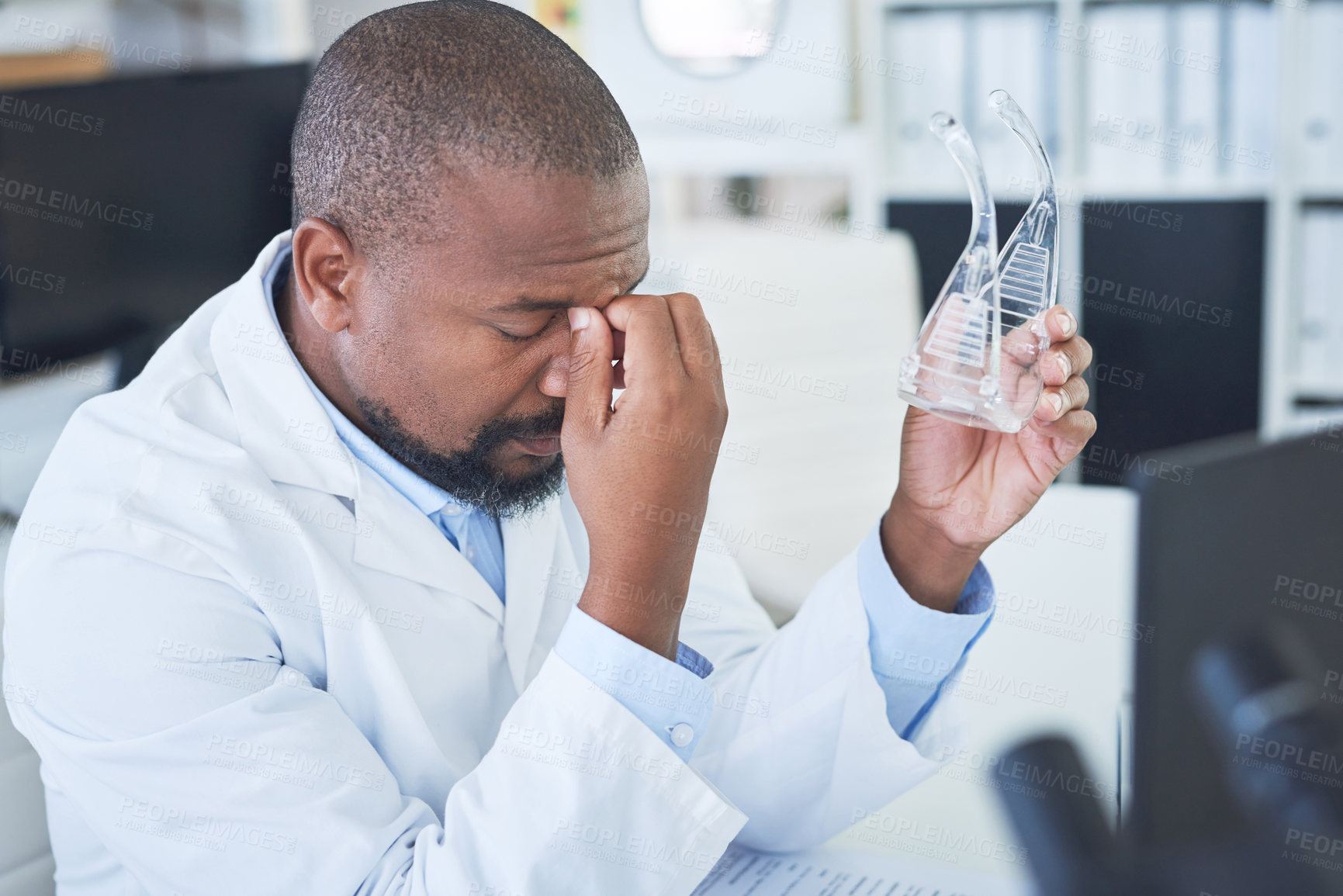 Buy stock photo Shot of a scientist looking stressed while conducting research in a laboratory