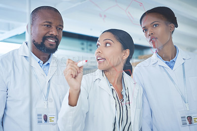 Buy stock photo Shot of a group of scientists having a brainstorming session in a laboratory