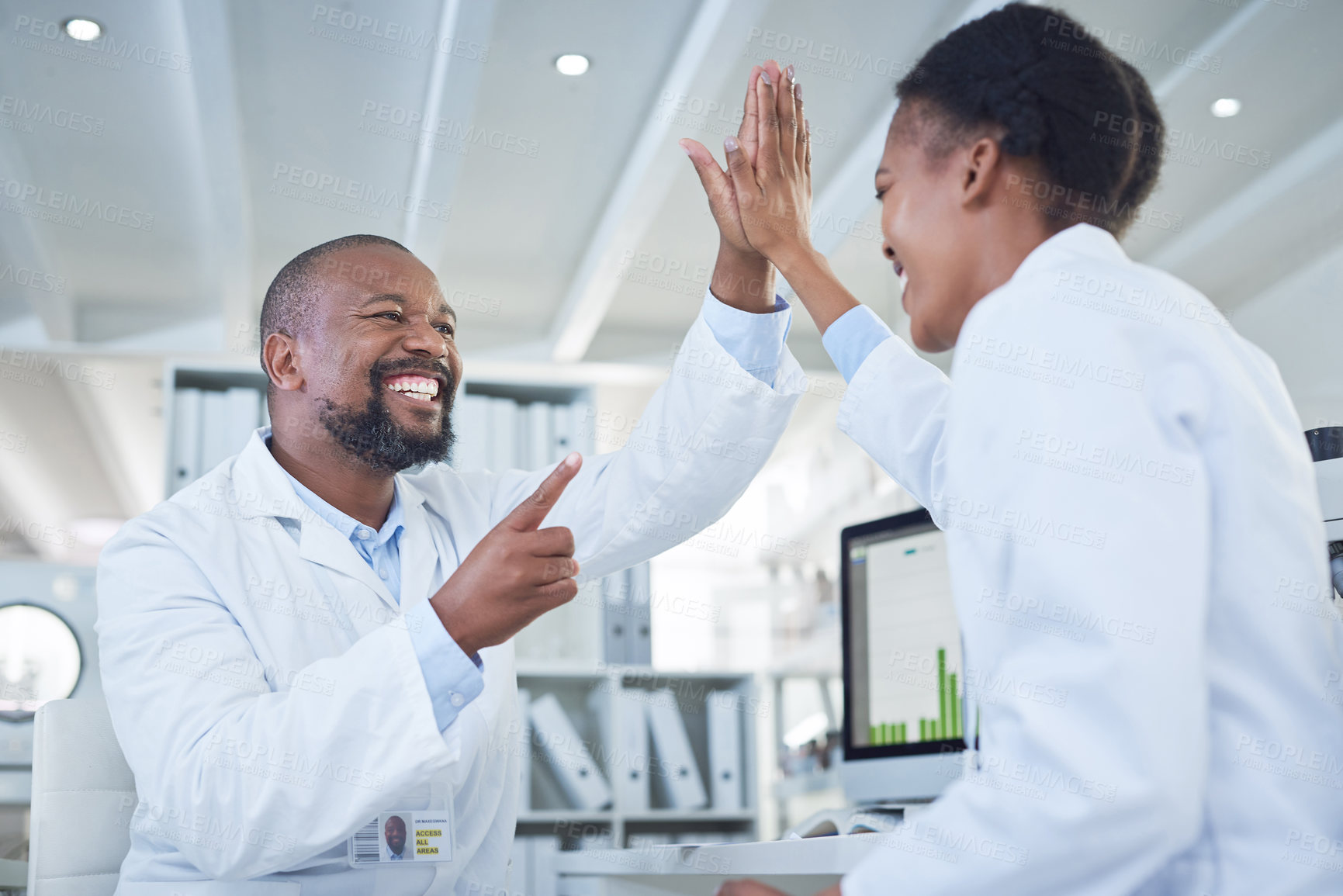 Buy stock photo Shot of two scientists giving each other a high five while conducting research in a laboratory