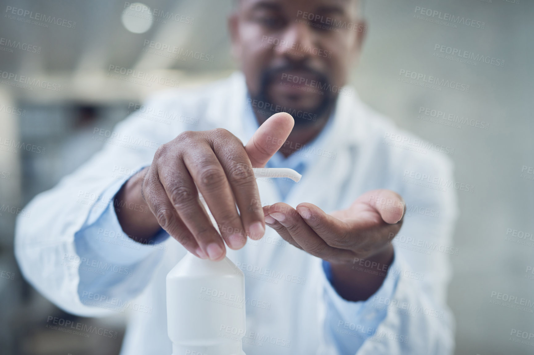 Buy stock photo Shot of a scientist disinfecting his hands while conducting research in a laboratory